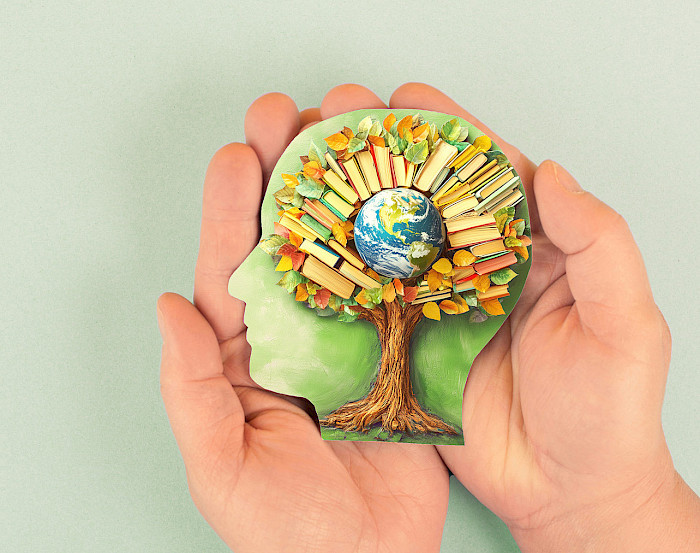 Kopf mit Baum, der in seiner Krone die Weltkugel und Bücher trägt